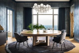 Navy walls in a dining room with statement chandelier