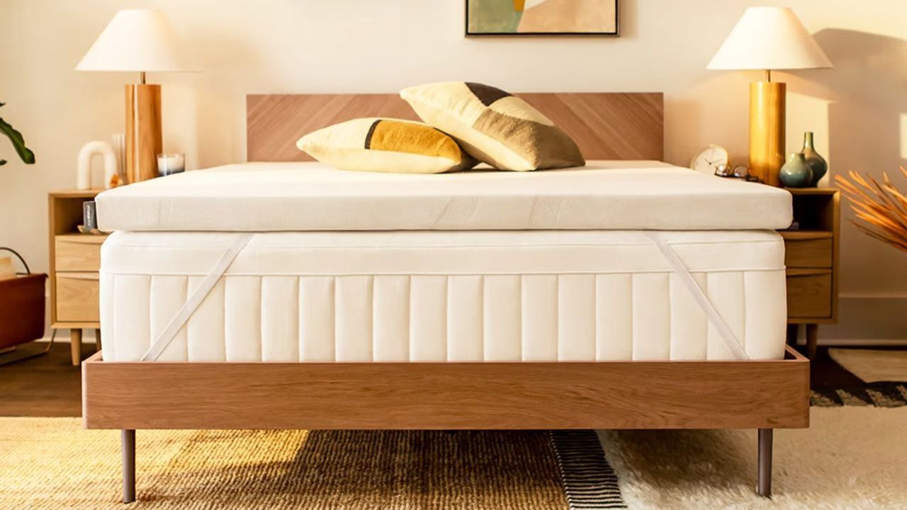 Tempur-Adapt Tempur-Topper on a mattress with a nightstand either side against a white wall. 