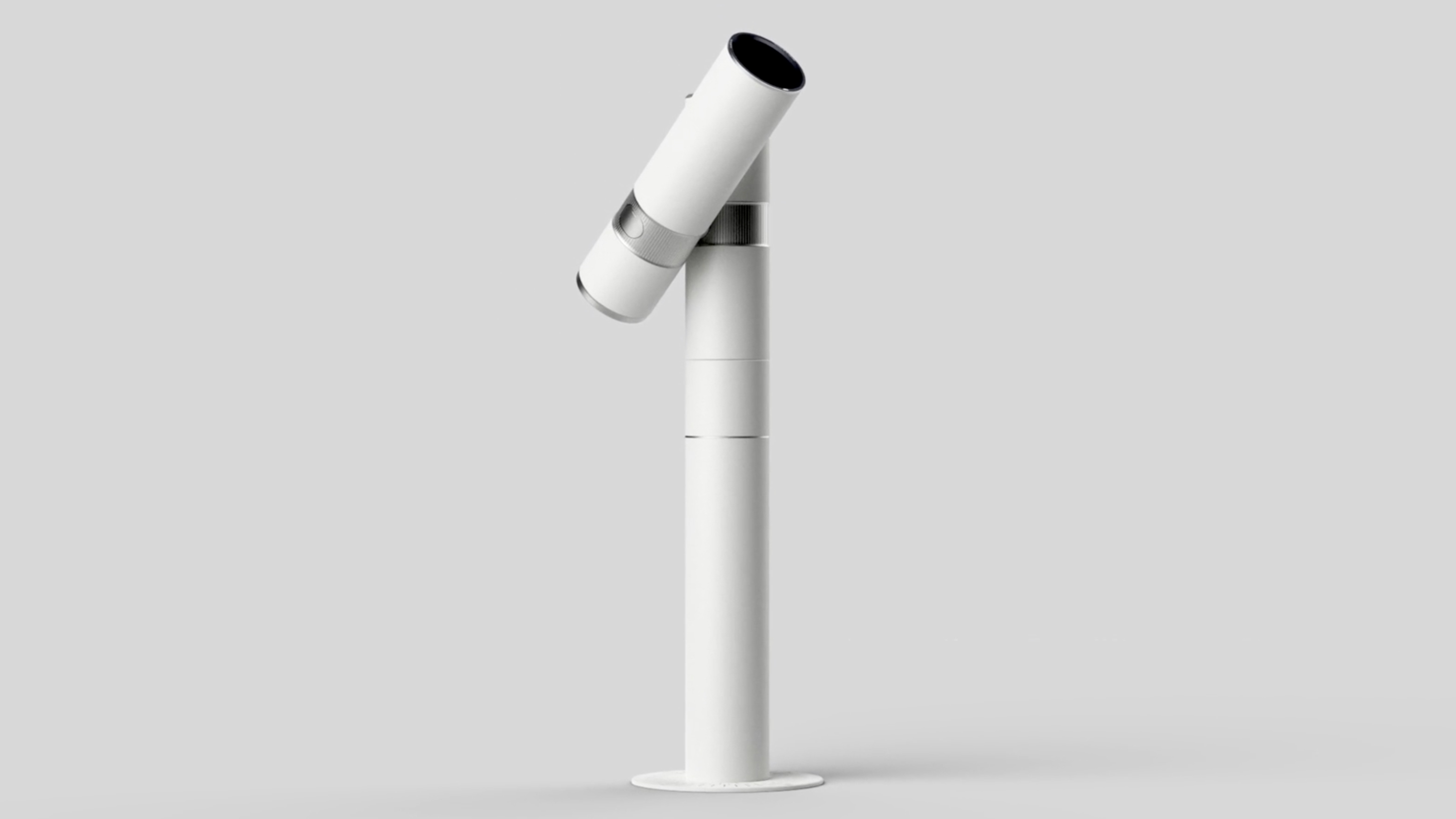 A sleek, modern white telescope mounted on a cylindrical base, angled slightly upward against a neutral background