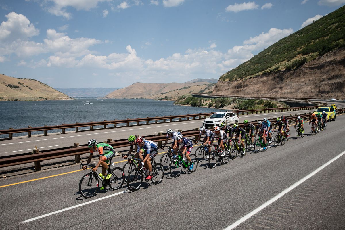 The peloton rides past a lake in the early going of stage 6 in Utah