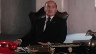 Walter Gotell sits at his desk while giving a briefing in The Spy Who Loved Me.