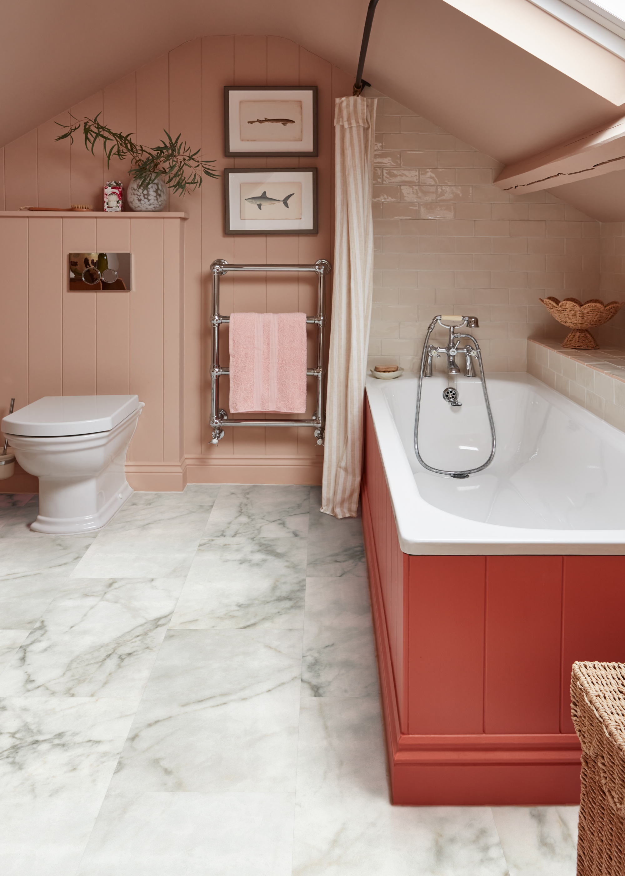 a pink walled bathroom with a red planked bath and marble tiled flooring
