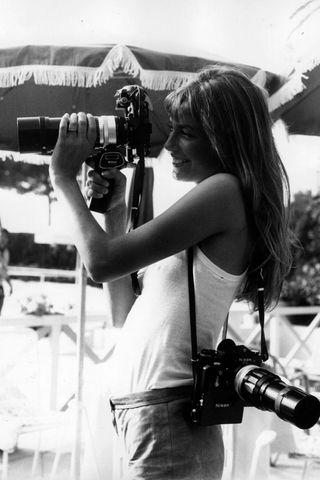 Jane Birkin taking a photograph with a camera on her back