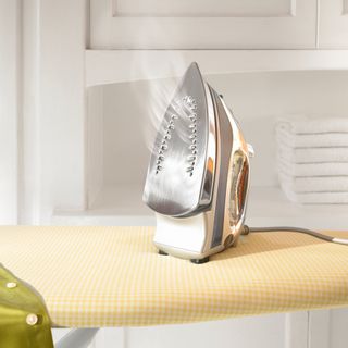 Steam iron propped up on top of ironing board