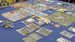 The board of Star Trek: Away Missions with models, cards, and tokens strewn over a blue tablecloth