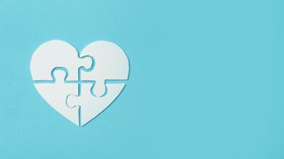 white heart shaped jigsaw on blue background