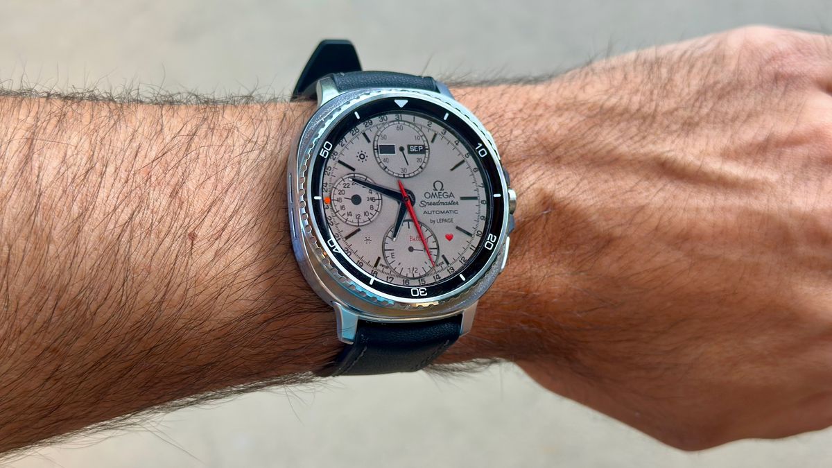 The Samsung Galaxy Watch 8 Classic on a person's wrist, showing a custom watch face from TIMEFLIK imitating an Omega luxury watch.