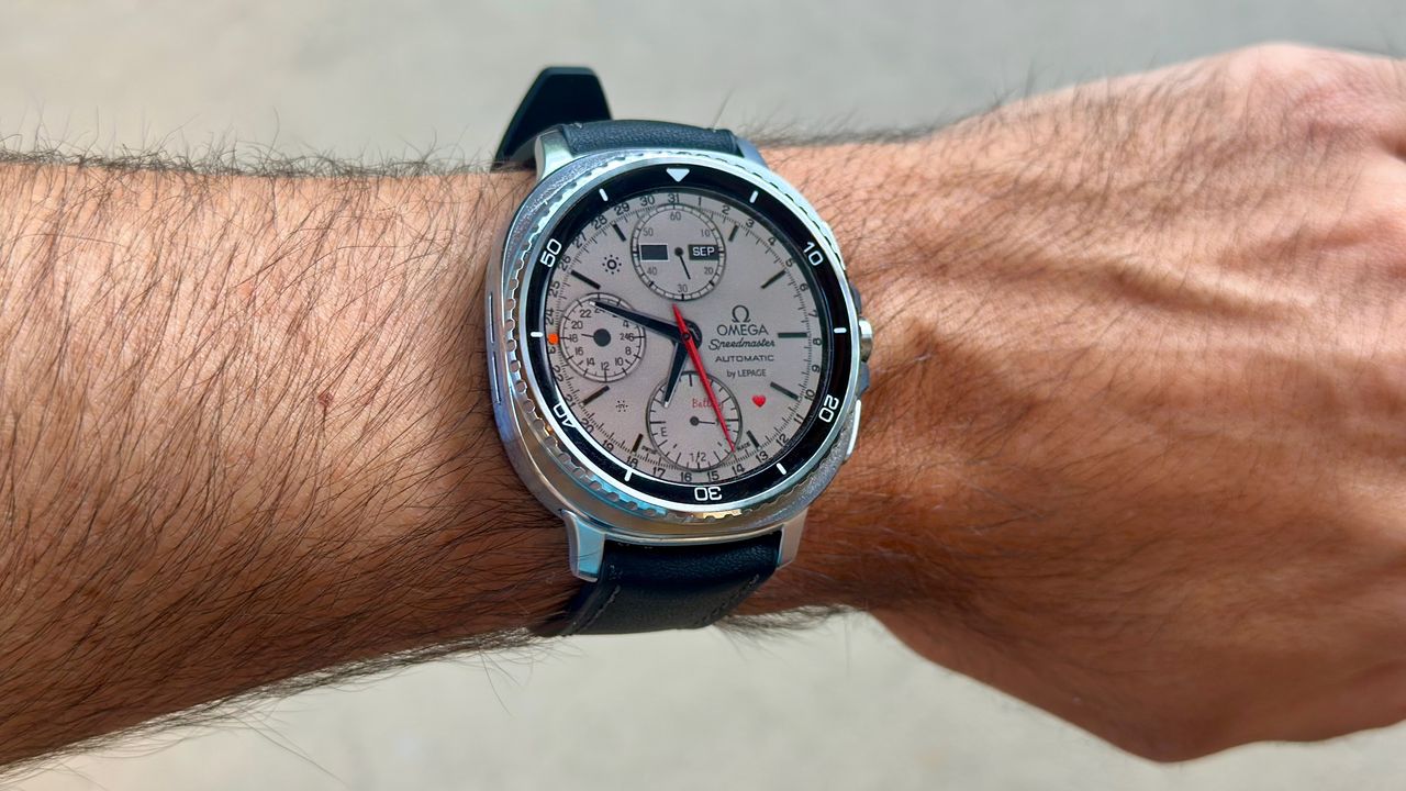 The Samsung Galaxy Watch 8 Classic on a person's wrist, showing a custom watch face from TIMEFLIK imitating an Omega luxury watch.