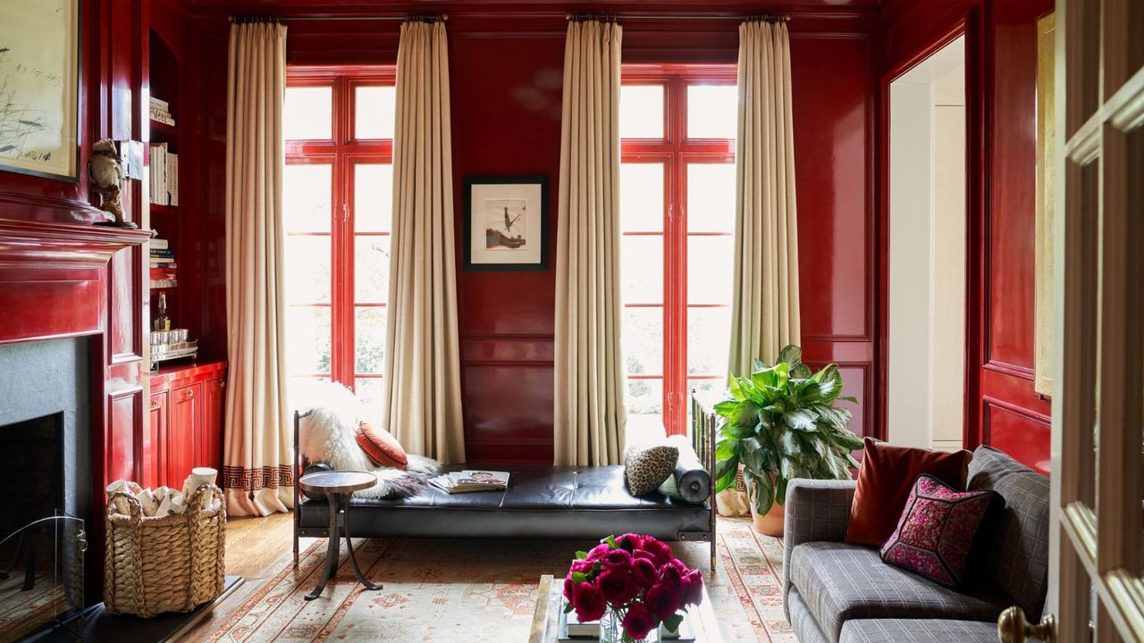 A red living room with color-drenched walls, large French doors and traditional decor. 