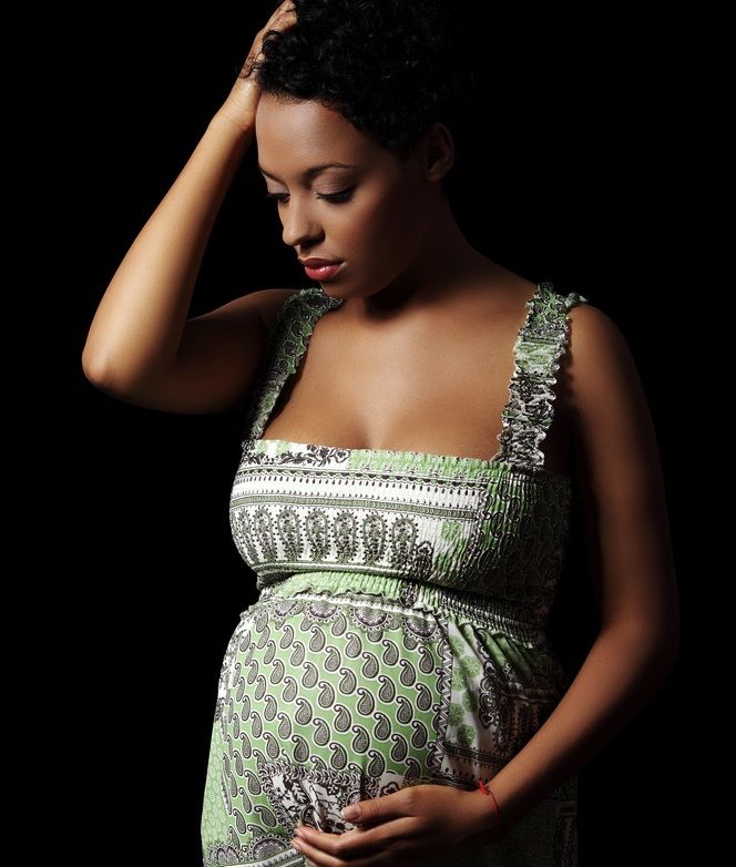 A pregnant woman looking sad.