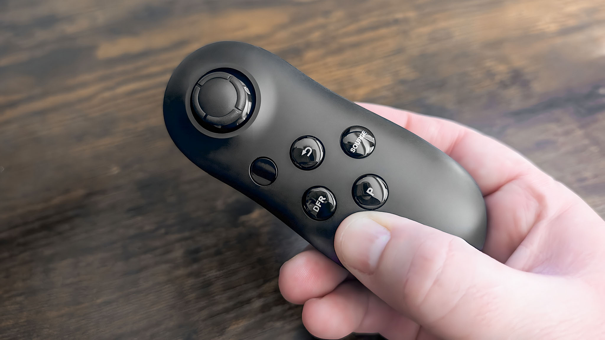 The remote that comes with the Acer Predator XB273K in a hand.