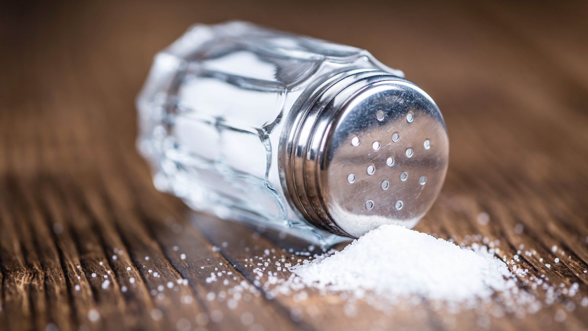 A bottle of table salt tipped on its side and spilled