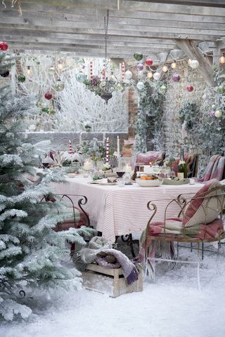 festive table under pergola with Christmas lights