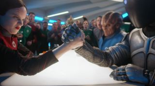 Isaac (Mark Jackson) arm-wrestles Lt. Alara Kitan (Halston Sage) in what has become a regular Friday fixture in the Orville's mess hall.