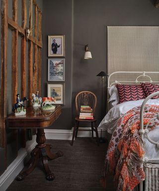 dark grey painted bedroom with a mahogany side table and a modern bed