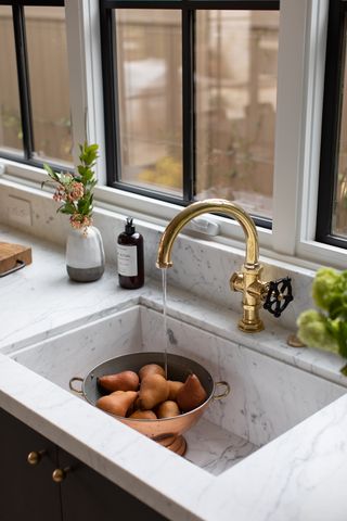 marble sink with bowl of pears, gold tap