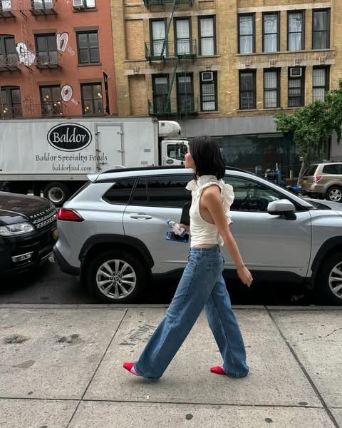 Woman in relaxed-low rise jeans and ruffle going out top