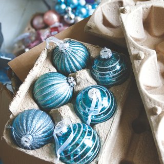 Close up of boxes of aqua blue Christmas tree glass baubles packaged safely in cardboard.