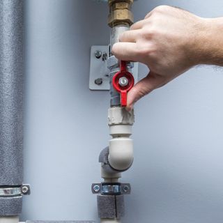 Hand turning internal stop tap with grey pipe and red handle