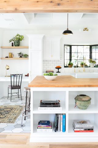 White kitchen ideas with open shelving on an island, wooden countertops and white subway tiles.