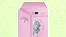 Pink washing machine with an open door on green background