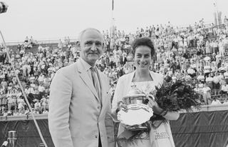 British tennis player Virginia Wade, holding a bouquet of flowers and the trophy