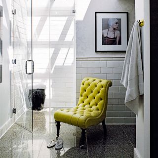 bathroom white wall green chair grey tile flooring and glass door