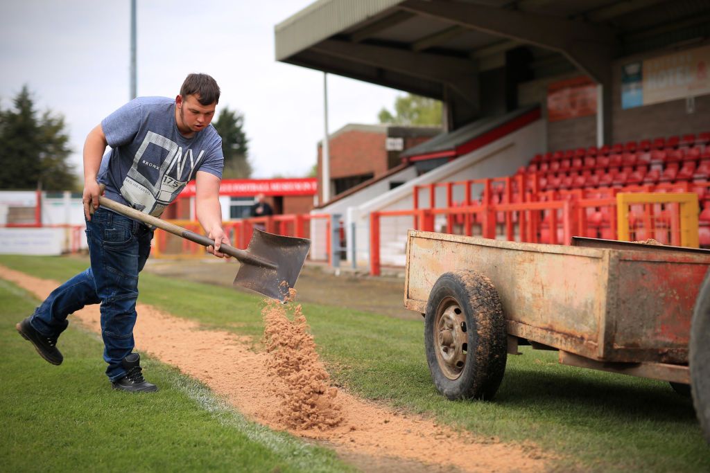 Northwich Victoria v Witton Albion - A groundsman spreads sand over the linesman&#039;s path along the touchline 