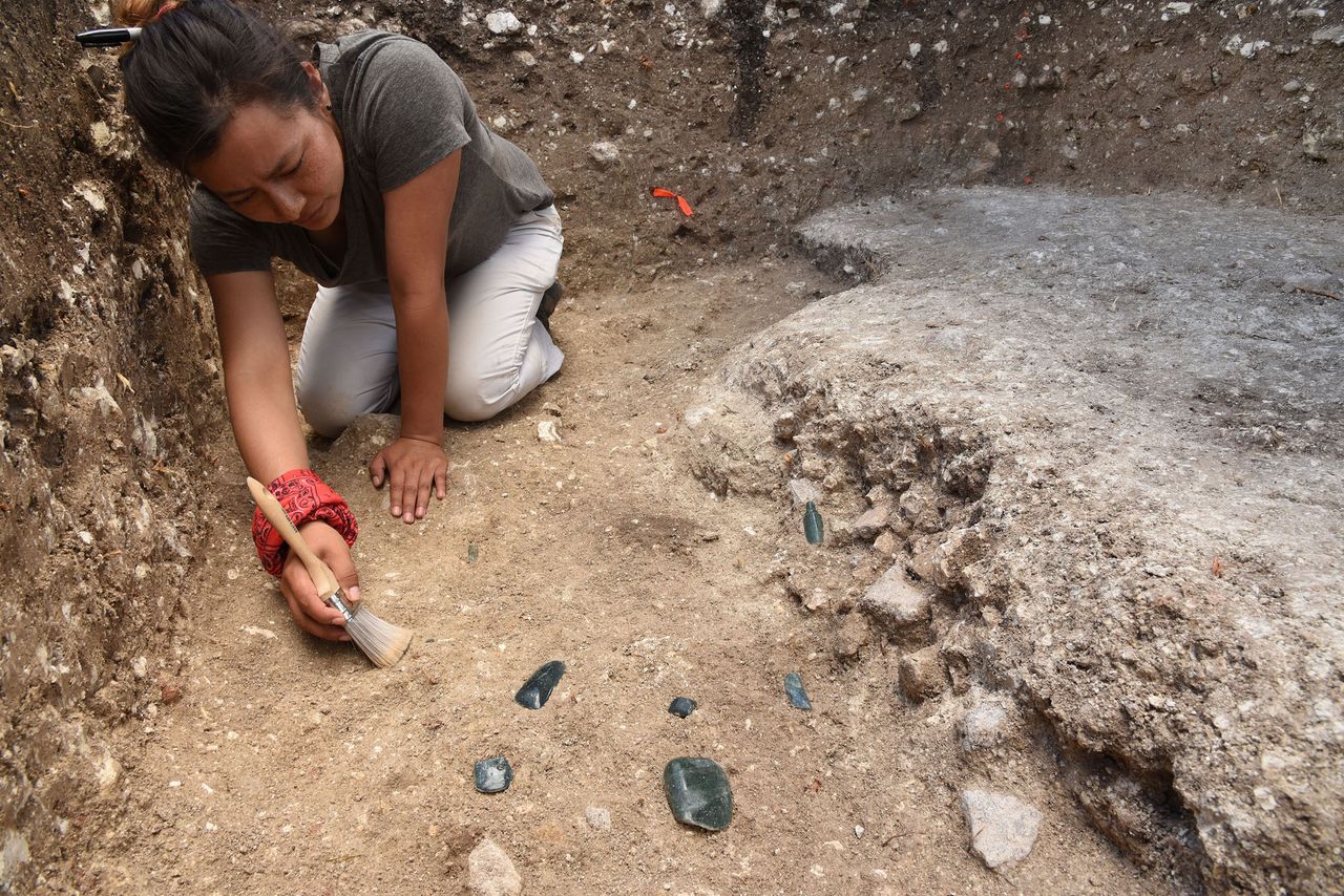 Melina Garcia excavates a cache with greenstone axes and a perforator at Aguada F&eacute;nix. Greenstone axes are found at other ancient sites, including San Isidro, Chiapa de Corzo, Ceibal and Civa.