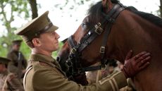 Still image from War Horse film, showing a horse with member of the army