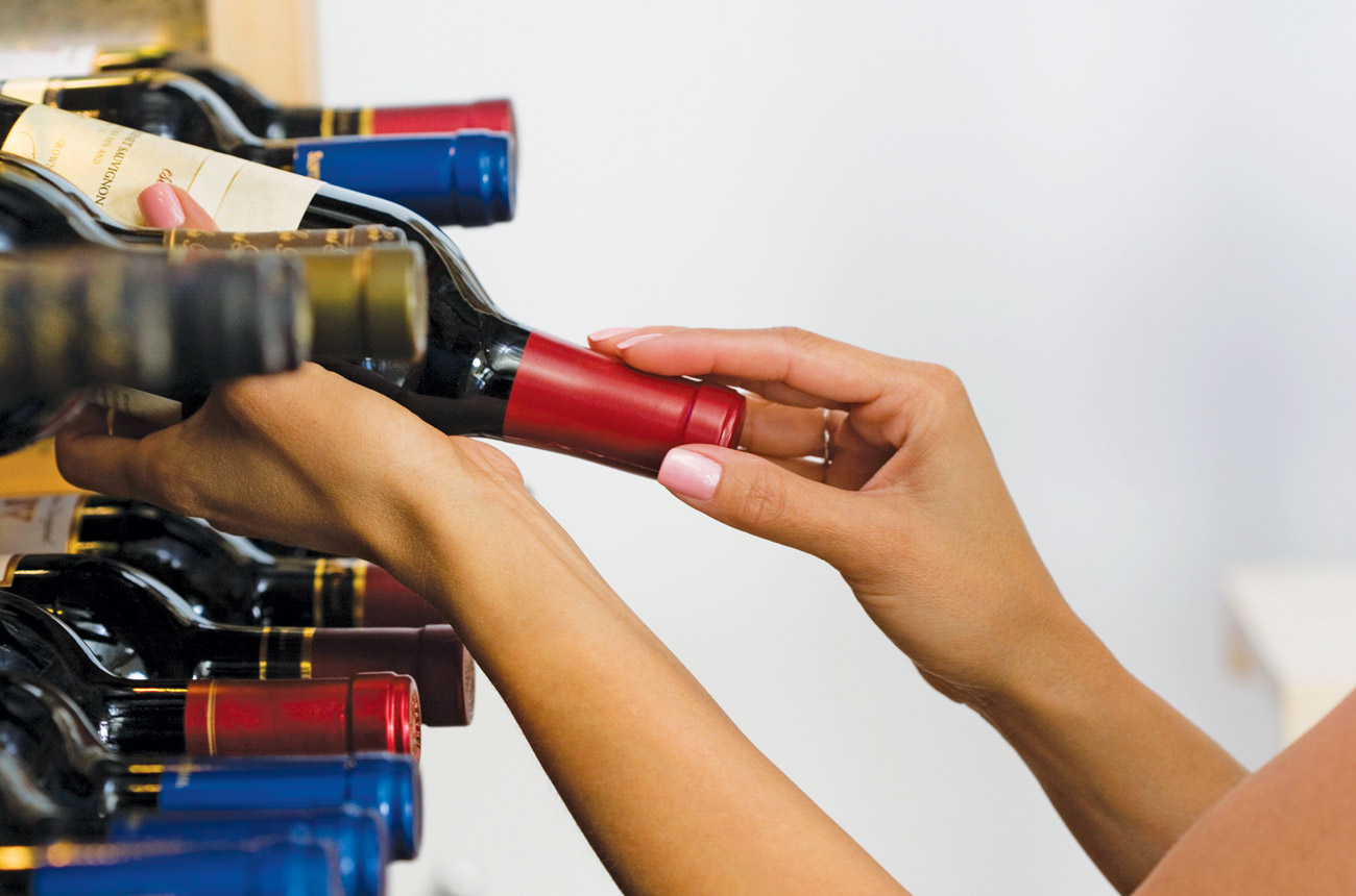 Taking a bottle of wine from a rack