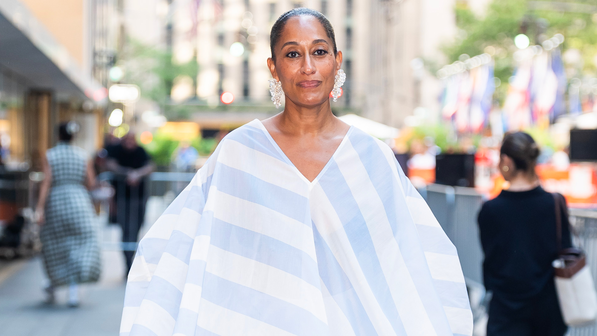 Tracee Ellis Ross wearing a flowy blue and white short. She has her hair in a slicked back bun.
