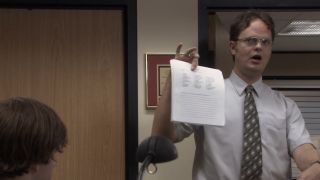 Dwight holding up a paper in The Office