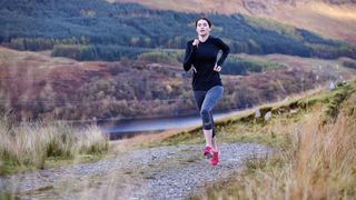 woman running on a trail in hills