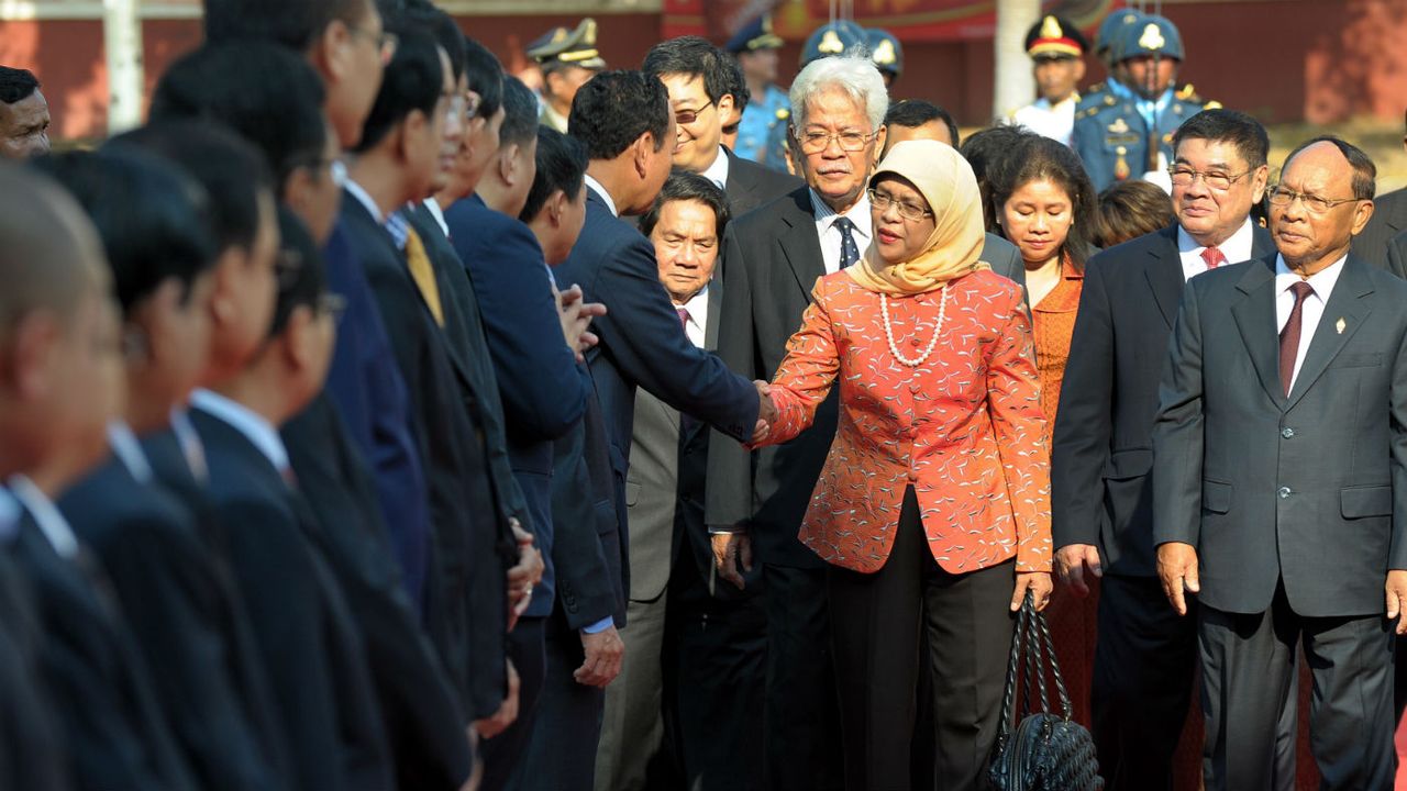 Halimah Yacob shakes hands with members of Singapore&amp;#039;s parliament