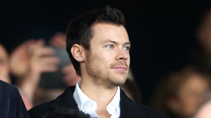 Harry Styles, English Singer, looks on prior to the Premier League match between Luton Town and Manchester United at Kenilworth Road on February 18, 2024 in Luton, England.