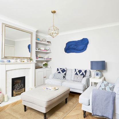 living room with light and dark blues, a mirror, sofa and lamp