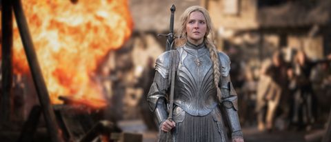 An armored Galadriel walks through a battle sequence during daytime in The Rings of Power