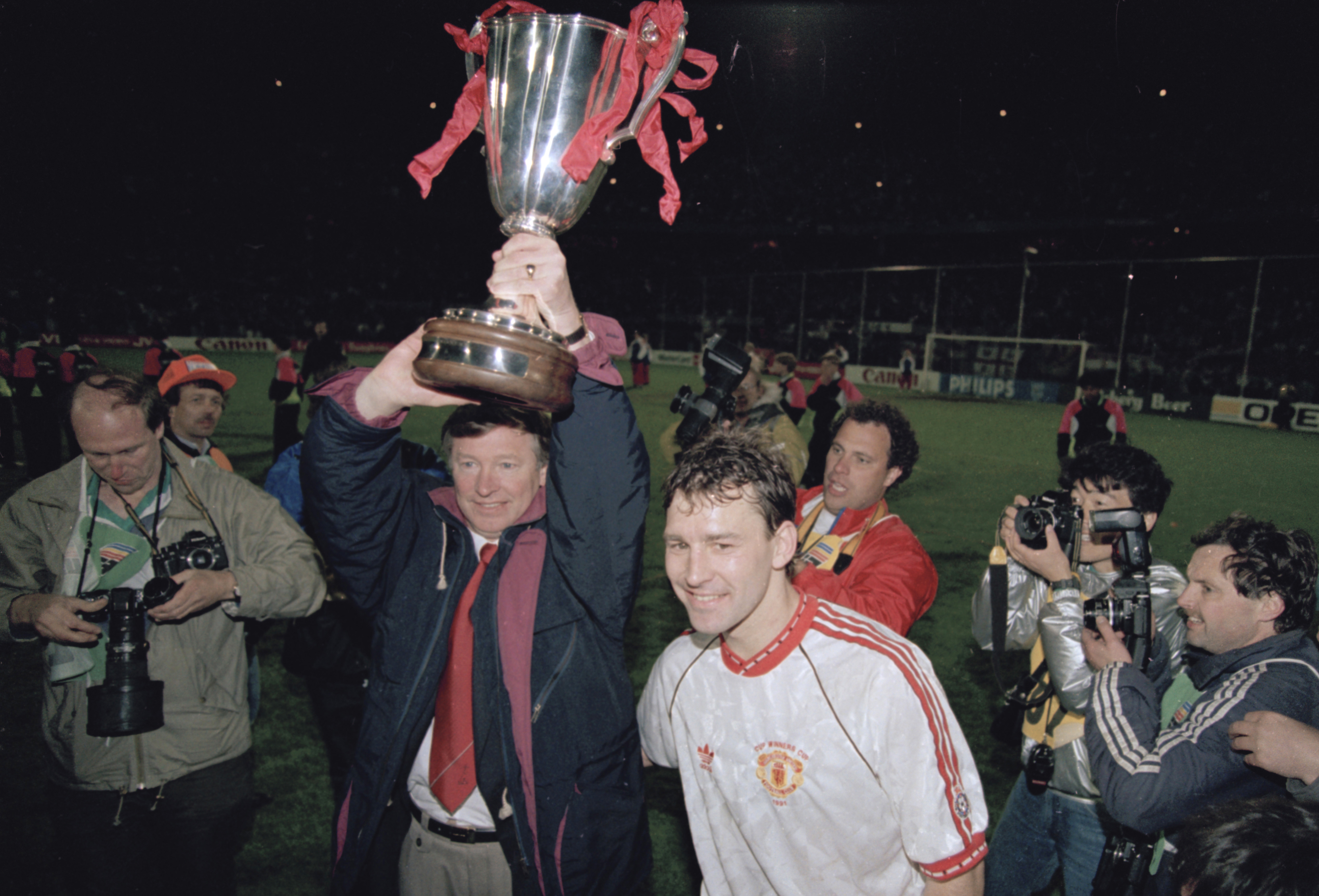 Alex Ferguson celebrates with the European Cup Winners' Cup alongside Bryan Robson after Manchester United's victory over Barcelona in Rotterdam in May 1991.