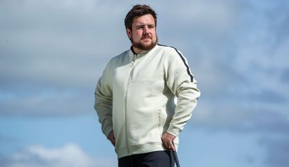 A golfer wears the Under Armour Tour Tips Full-Zip Bomber Jacket