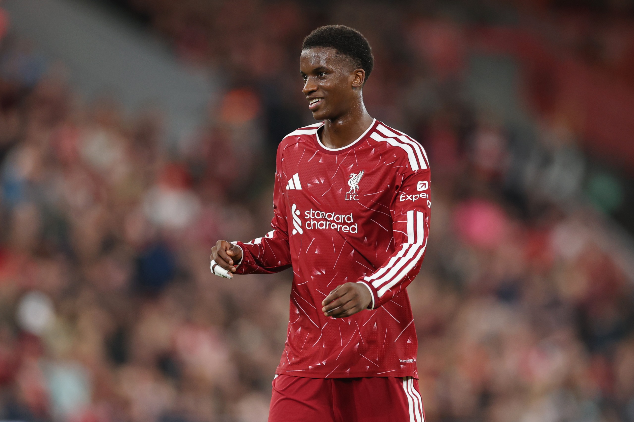 Trey Nyoni on the pitch for Liverpool, smiling.