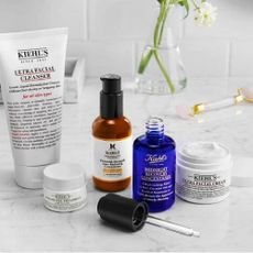 A marble surface with a variety of Kiehl's products on. 