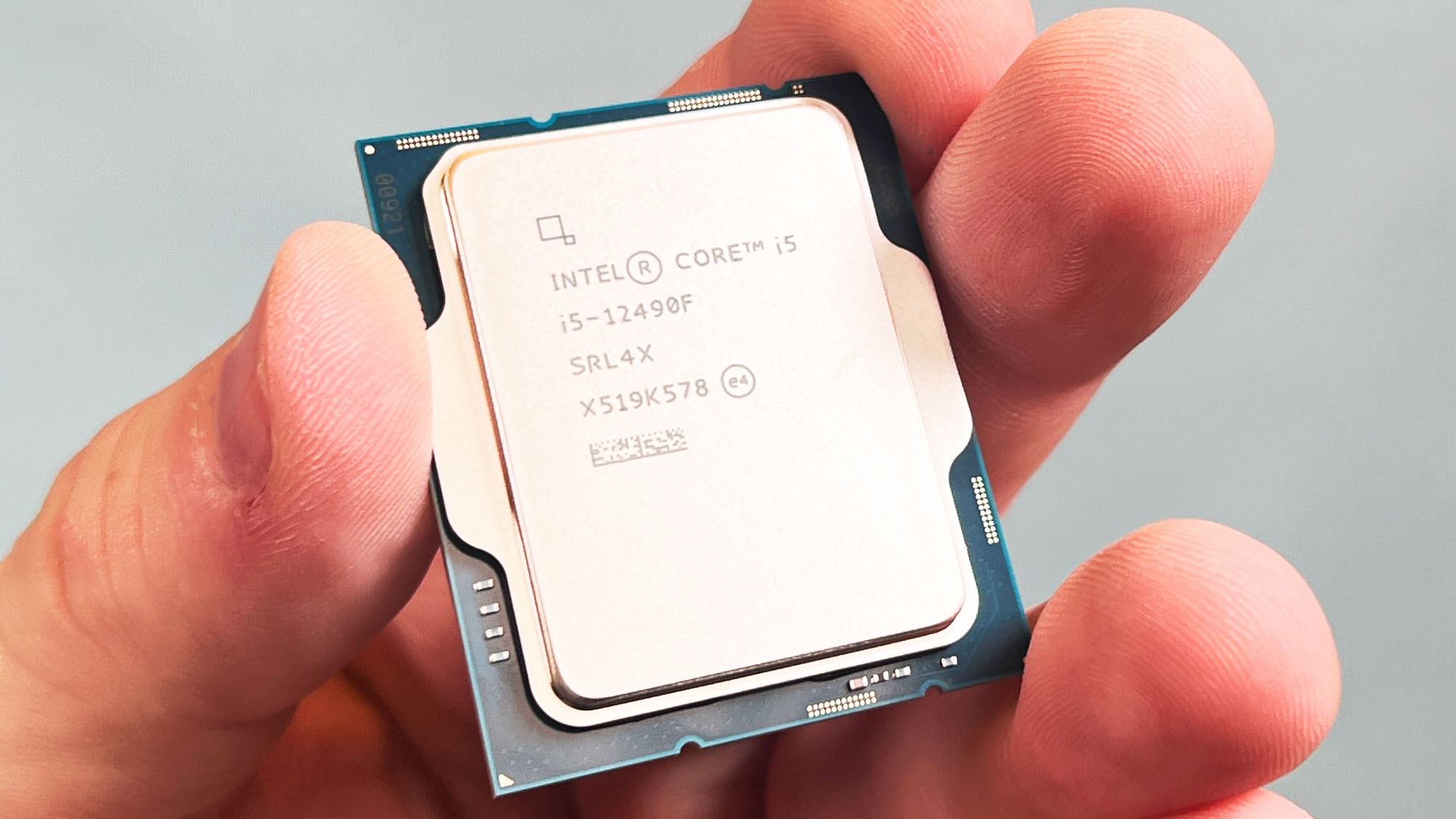 An Intel Core i5-12490F held in a masculine hand