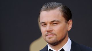 Leonardo DiCaprio poses on a red carpet in a suit and tie