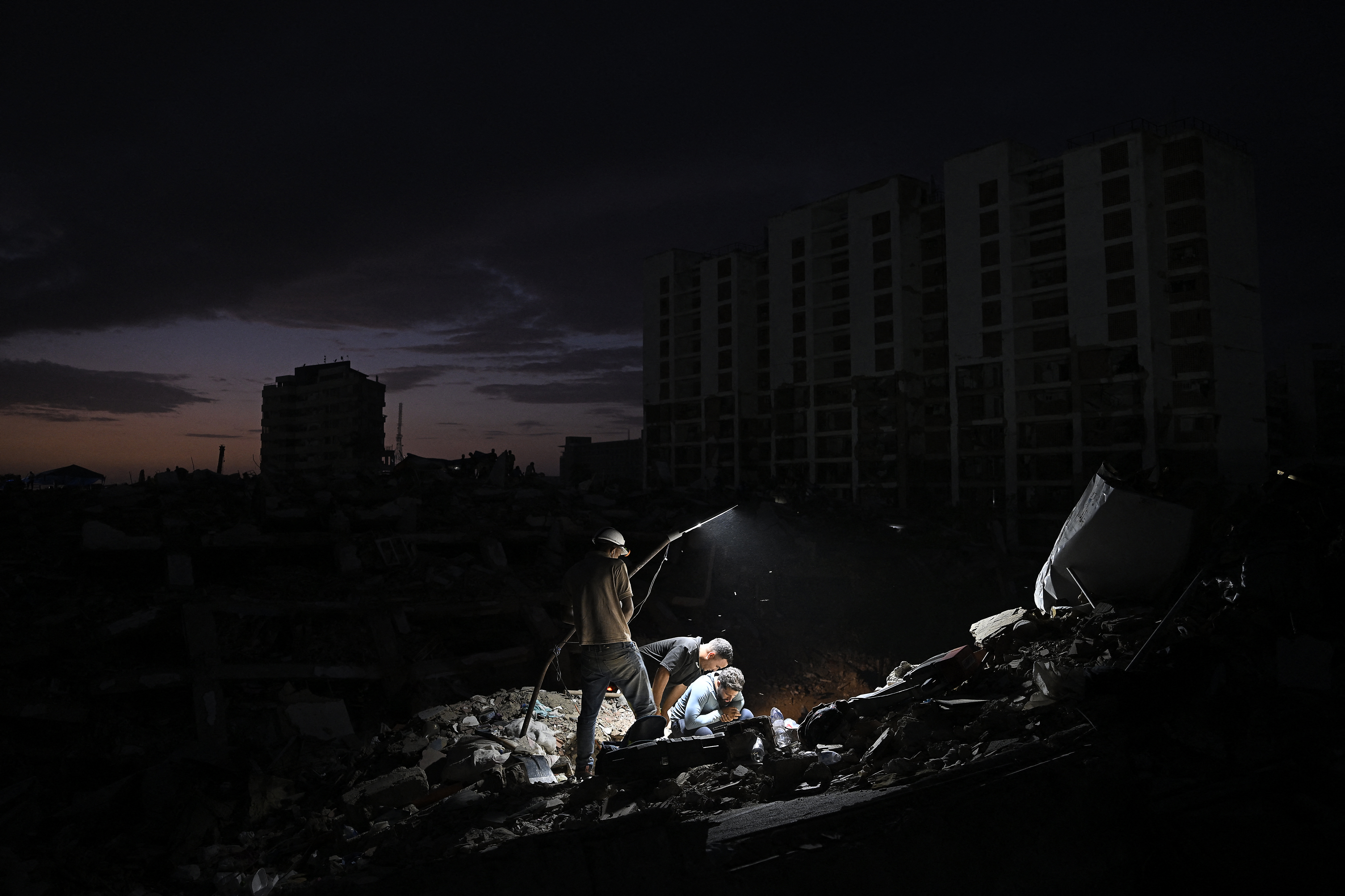 Volunteers and relatives of victims search for their loved ones amid debris of a collapsed building in Caraballeda, La Guaira state, Venezuela, on July 16, 2026. The death toll from last month's devastating twin earthquakes in Venezuela has surpassed 4,800, while 16,740 people were injured and nearly 21,000 were made homeless the government reported on July 15. (Photo by Federico PARRA / AFP)