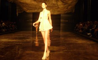 Model at the end of the runway in a short dress in neutral tones