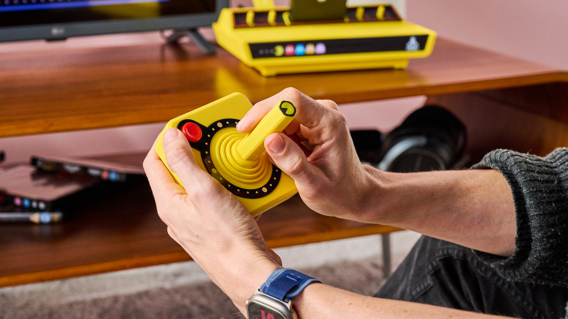 A man holding the CX40+, playing Pac-Man.