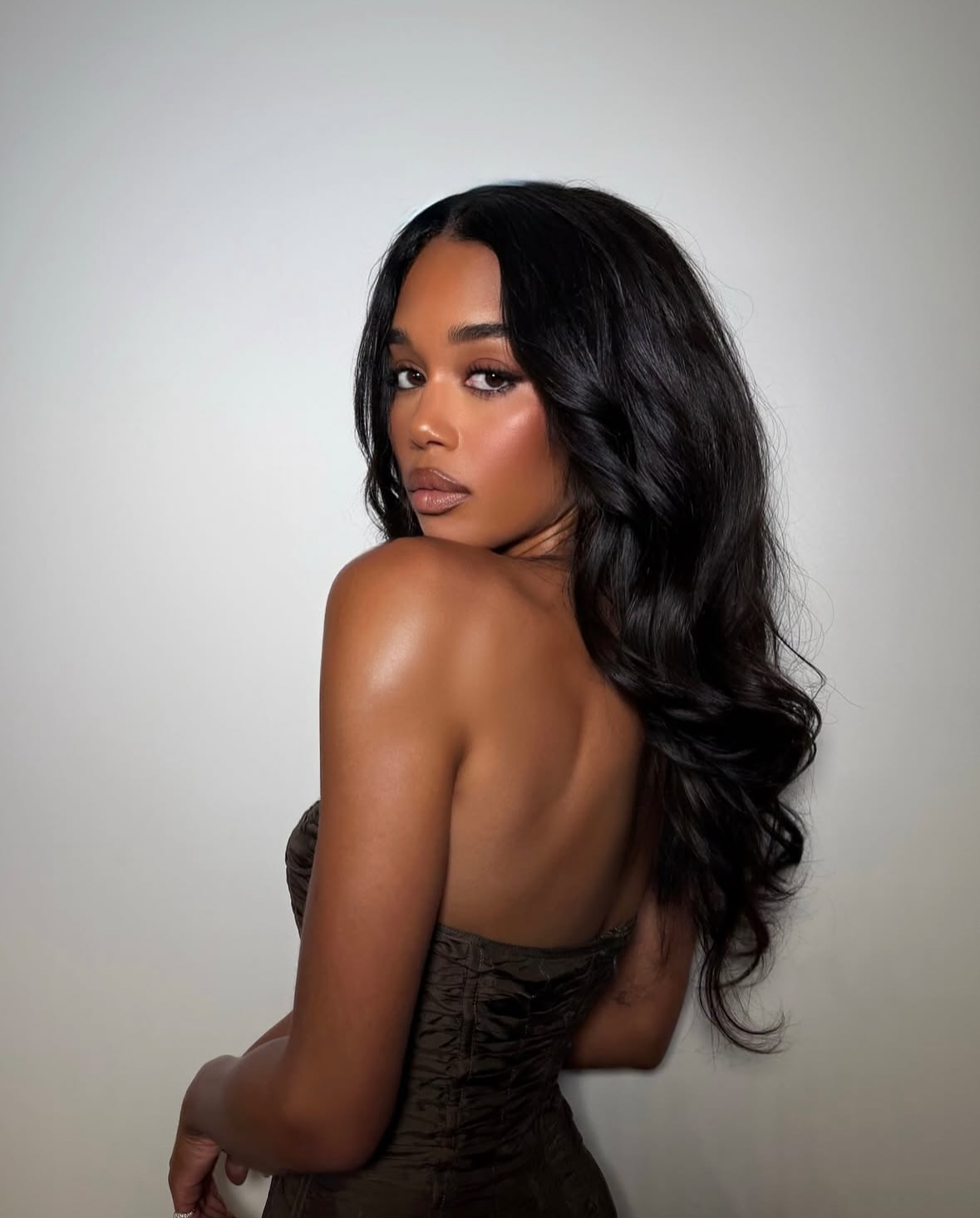 Laura Harrier with a long V-cut hairstyle.