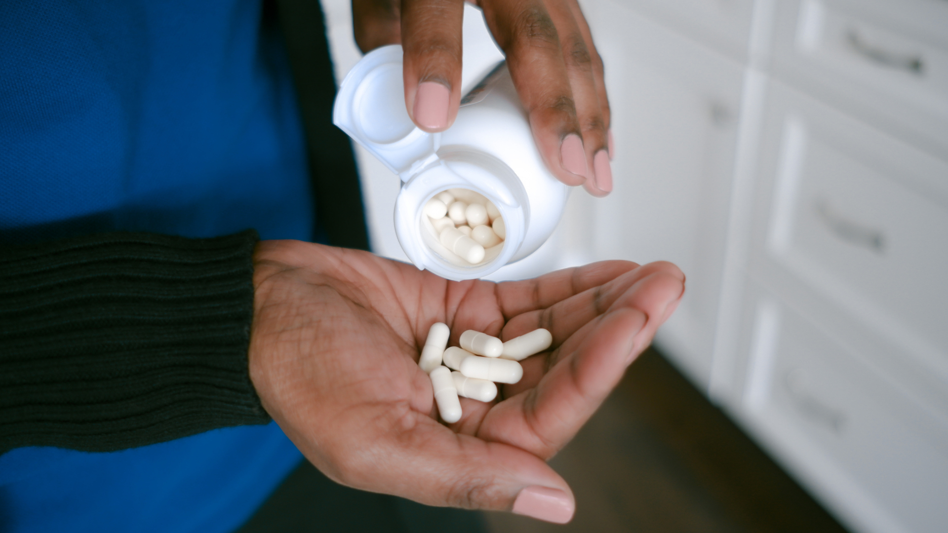 woman taking a handful of probiotic supplements