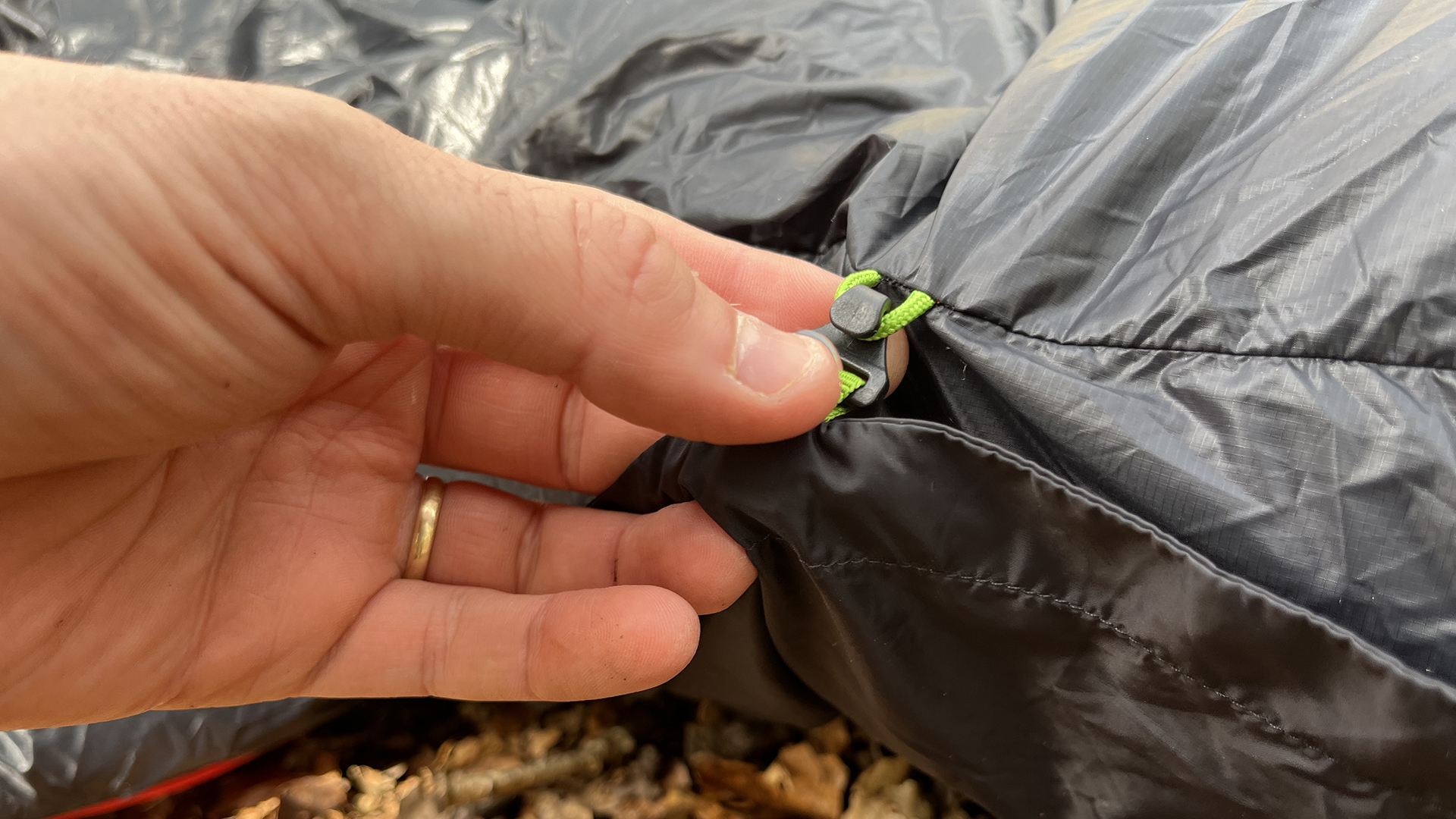 A hand holding the clips on the side of a Zenbivy Ultralight Bed.